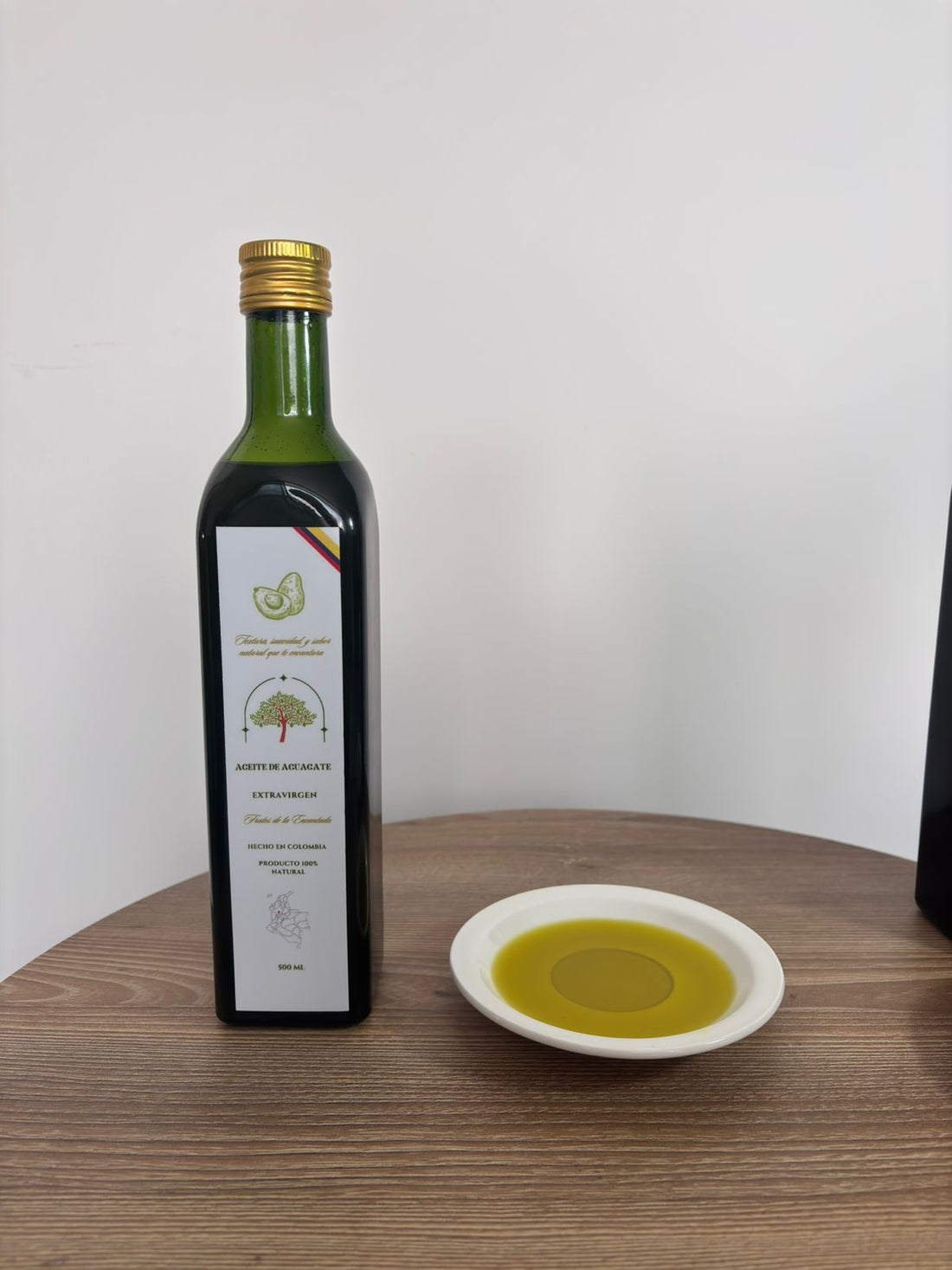 Botella de aceite de aguacate con un plato de aceite servido